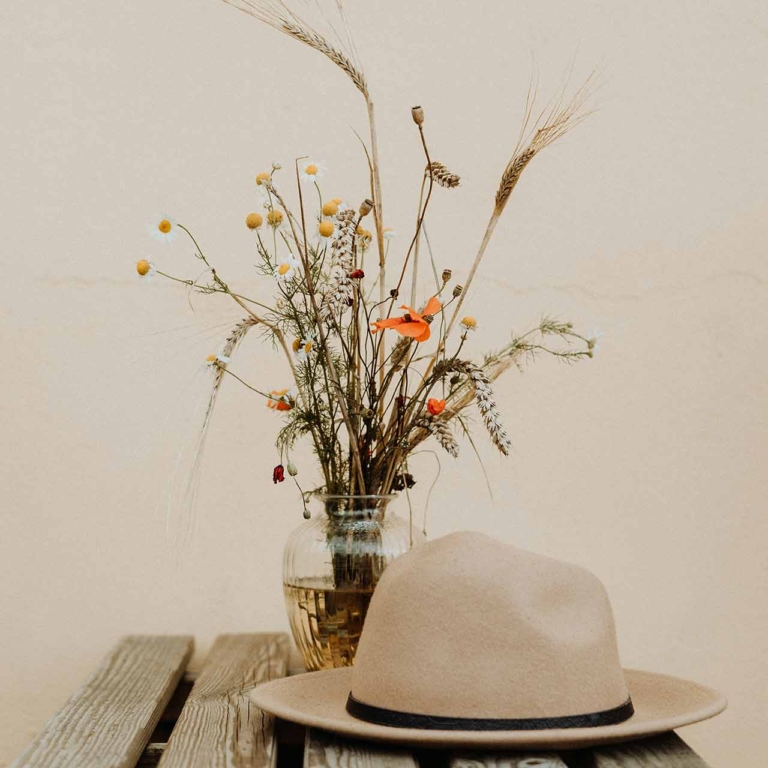 Hat on a bench with flowers